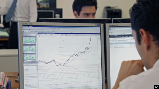 Traders at the Saxo Banque study their screens in their offices in Paris, August 10, 2011