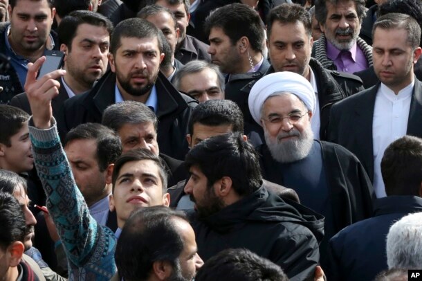 An Iranian man takes a selfie, hoping to capture Iranian President Hassan Rouhani in his picture during a rally marking the 37th anniversary of the Islamic revolution in Tehran on Feb. 11, 2016.