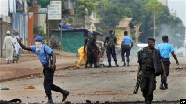 Guinean police carrying automatic weapons clear the mostly Peul suburb of Bambeto in Conakry, Guinea, 16 Nov.2010, as groups of UFDG youth set up barricades. A de-facto curfew is in effect in the area, residents staying inside, one day after it was announ