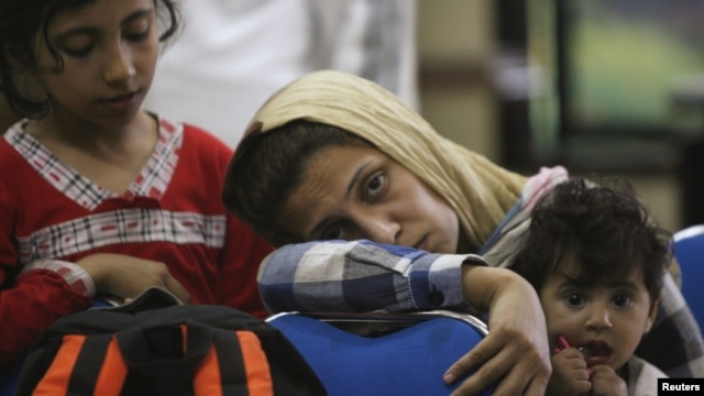Asylum seekers wait in a police station in Surabaya , East Java province, July 29, 2012. 