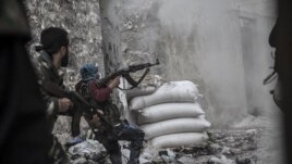 A rebel fighter retreats for cover as enemy fire targets the rebel position during clashes at the Moaskar front line, one of the battlefields in the Karmal Jabl neighborhood, of Aleppo, Syria, October 24, 2012.