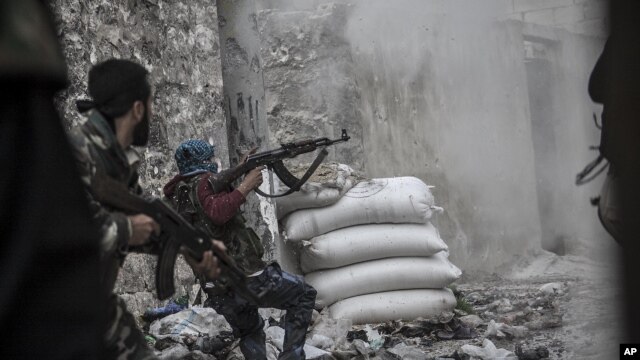 A rebel fighter retreats for cover as enemy fire targets the rebel position during clashes at the Moaskar front line, one of the battlefields in the Karmal Jabl neighborhood, of Aleppo, Syria, October 24, 2012.