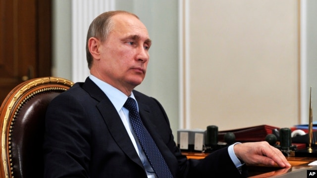 File - Russian President Vladimir Putin listens during a meeting in the Novo Ogaryovo residence, outside Moscow, April 2015.
