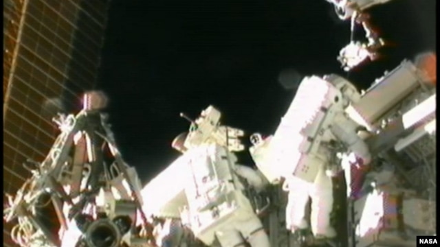 Astronot AS Sunita Williams (kanan) saat melakukan perbaikan stasiun antariksa internasional (foto: dok). 