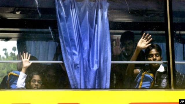Sri Lankan children wave as they and other ethnic Tamil migrants leave the Merak seaport in Banten province by bus bound for a detention facility as they finally agreed to be relocated, 19  Apr 2010