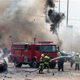 Smoke and debris fill the sky after a car bomb explodes alongside firemen responding to an initial car bomb that had exploded five minutes earlier in Abuja, Oct 1 2010