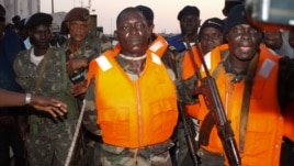 Guinea Bissau soldiers escort Captain Pansau N'Tchama (C), accused of being the mastermind behind the October 21 attack on an elite army barracks, shortly after his arrest in Bolama, on October 27, 2012.