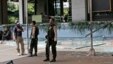 Police officers stand guard outside a damaged Starbucks cafe after an attack in Jakarta, Indonesia, Jan. 14, 2016.