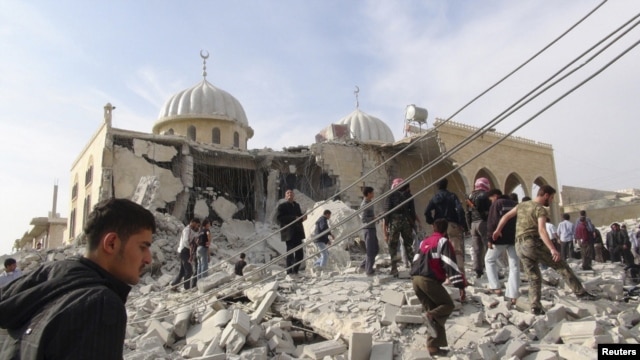 Residents and members of the Free Syrian Army inspect Bilal mosque, which activists said was damaged after it was fired upon by a Syrian Air Force fighter jet loyal to Syria's President Bashar al-Assad, at Marat al-Numan near the northern province of Idli