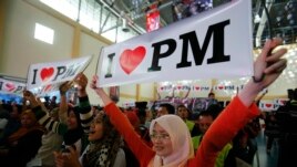Malaysian Izzati Zaidi (R), 24, and her friends show placards in support of Malaysia's Prime Minister Najib Razak during the launch of the "Voices of My Generation" youth programme in Kuala Lumpur, April 12, 2013.