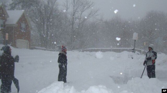 A man shovels snow outside his home in Fairfax, Virginia, 7 Feb. 2010