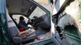 An Afghan policeman inspects the interior of a car belonging to the chief of police of Nimroz province, that was hit by a roadside bomb, in the Hadraskan district of Herat province, December 10, 2012.