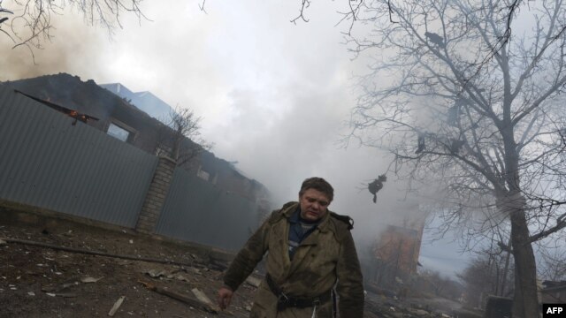 Lính cứu hỏa phía trước nhiều căn nhà bị phá hủy sau các vụ pháo kích ở thành phố miền đông Donetsk của Ukraine, ngày 3/2/2015.