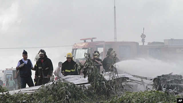 Firemen spray fire retardant on plane L410 of Noar Airlines that fell near Boa Viagem beach in Recife, the capital of the northeastern state of Pernambuco, July 13, 2011