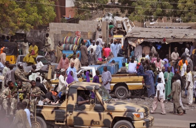FILE - In this photo taken Jan. 27, 2015, Nigerian soldiers on a truck patrol at a market after recent violence in areas surrounding Maiduguri. In a major offensive against Boko Haram, Nigerian and Chadian jets are bombing the Islamic extremists.