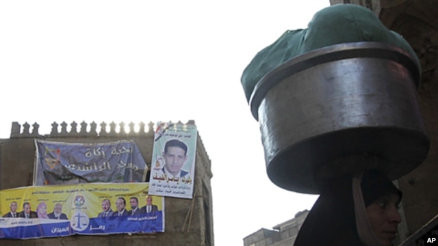 A woman walks near an election poster of Egypt's Muslim Brotherhood "The Freedom and Justice Party'" in the old city of Cairo December 2, 2011.