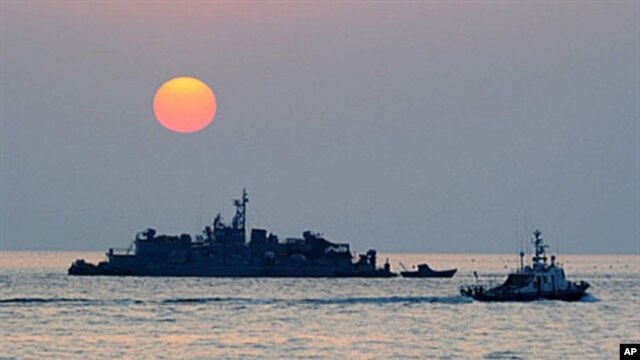 A South Korean goverment ship (R) sails by Navy MSB (Movement Sea Base) off the South Korea-controlled island of Yeonpyeong near the disputed waters of the Yellow Sea, 22 Dec 2010
