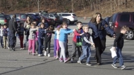 Polisi wakielekeza watoto kuondoka katika shule ya msingi ya Sandy Hook .
