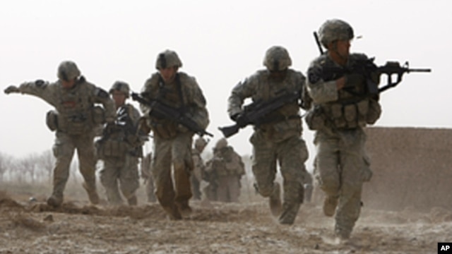 A US soldier returns fire as others run for cover during a firefight with insurgents in the Badula Qulp area, west of Lashkar Gah in Helmand province, southern Afghanistan, February 14, 2010