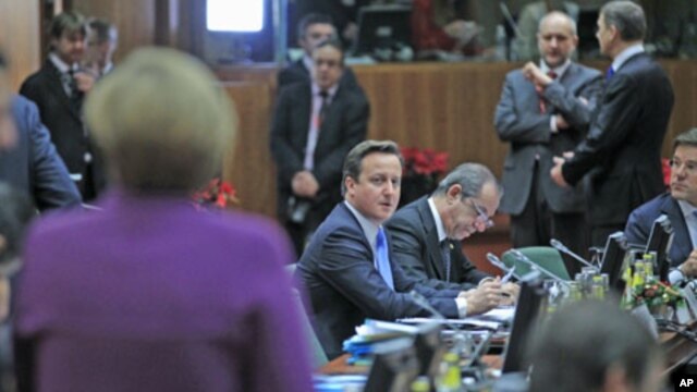Britain's Prime Minister David Cameron (C) looks at Germany's Chancellor Angela Merkel (L) at a European Union summit in Brussels, December 9, 2011.