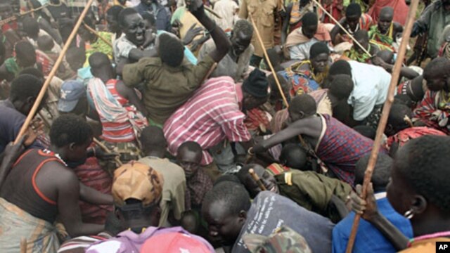 Villagers from Dadinga tribe struggle to get food after World Food Program staff distributed supplies in the village of Lauro in Eastern Equatoria State, South Sudan, April 2, 2010. 