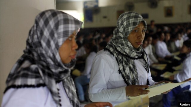 A Indonesian migrant worker heading for Middle East countries holds her passport documents at an immigration office. 