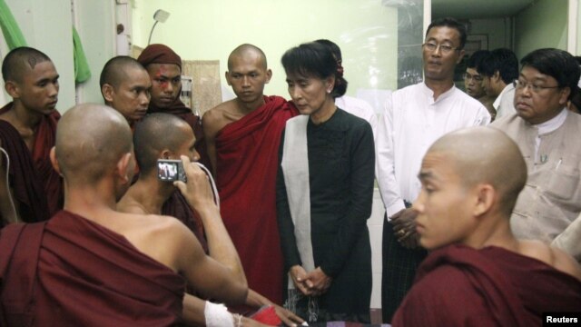 Aung San Suu Kyi visits Buddhists monks wounded in police crackdown on protests against a copper mine project, Nov. 2012.