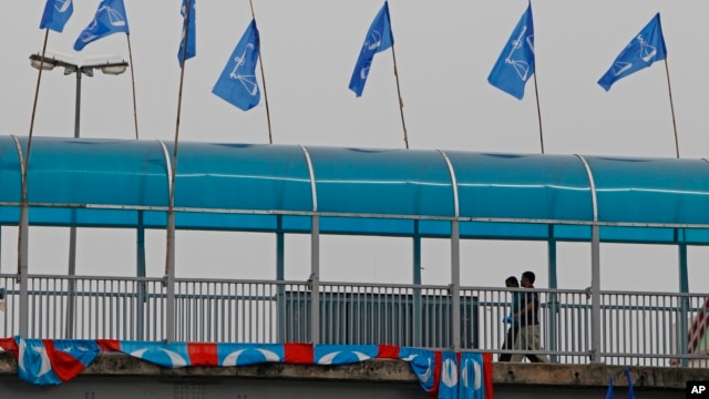 Men walk on a crossover bridge with flags of Malaysia's ruling party National Front on display for the upcoming general elections, in Kapar, outside Kuala Lumpur, Malaysia, April 10, 2013.