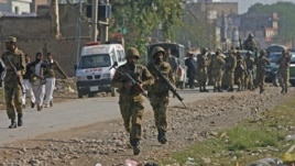 Pakistani army soldiers run towards a gun battle with Taliban militants near Peshawar's airport, December 16, 2012.