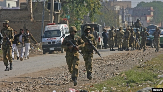 Pakistani army soldiers run towards a gun battle with Taliban militants near Peshawar's airport, December 16, 2012.