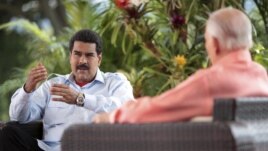 Venezuela's acting President Nicolas Maduro (L) speaks during an interview in Caracas, March 16, 2013, in this handout photo provided by the Miraflores Palace.
