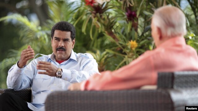 Venezuela's acting President Nicolas Maduro (L) speaks during an interview in Caracas, March 16, 2013, in this handout photo provided by the Miraflores Palace.