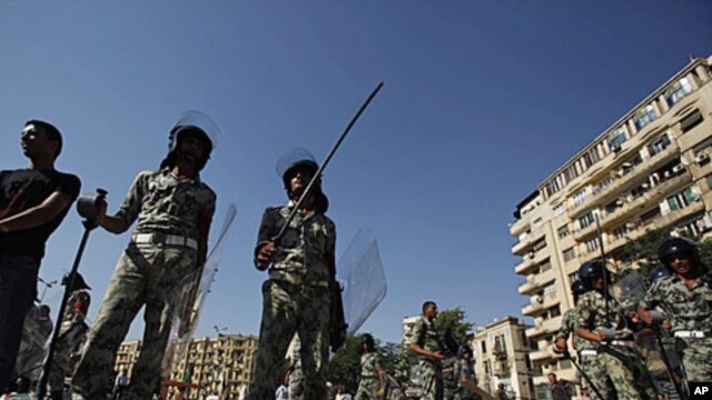 Military personnel stand next to dismantled tents at Tahrir Square in Cairo, August 1, 2011