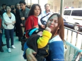王登朝的妻子怀抱幼子与围观者在法院外。(网络图片)