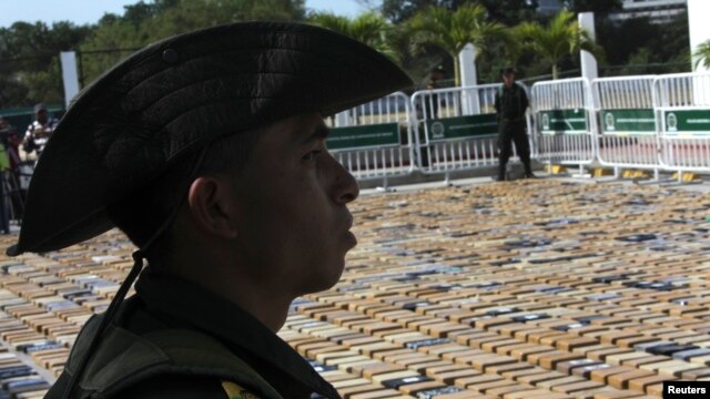 Cảnh sát đứng gác bên cạnh các gói cocaine bị tịch thu ở cảng Cartagena, 22/1/2013.