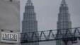 FILE - A 1MDB (1 Malaysia Development Berhad) logo is set against the Petronas Twin Towers at the flagship development site, Tun Razak Exchange in Kuala Lumpur, Malaysia.