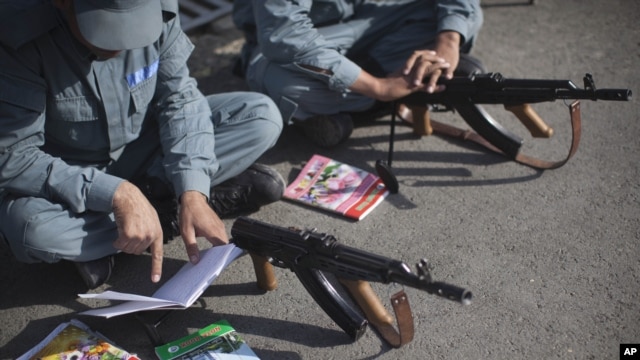 Afghan National Police recruits study their notes on how to use a Kalashnikov rifle during a training session at the police academy in Kabul, Afghanistan, October 9, 2012.