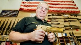 Vecinos de Aurora, Colorado, muestran banderas estadounidenses al otro lado de la calle de los cines Century 16, donde ocurrió la matanza el viernes. Las ventas de armas han aumentado desde entonces.