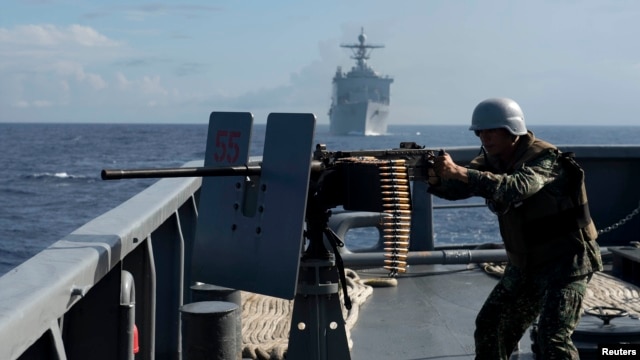 FILE - The Philippine Navy is upgrading its fleet amid growing maritime disputes. Here, one of its troops fires a .50-caliber machine gun during a bilateral maritime exercise between the Philippine Navy and U.S. Navy in the South China Sea, June 29, 2014.