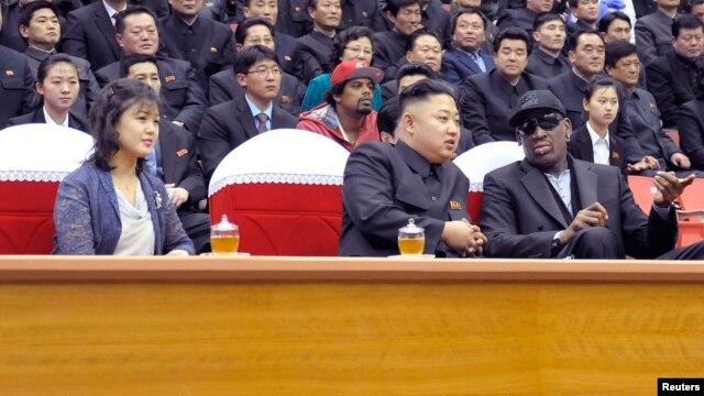 Vợ chồng ông Kim Jong Un cùng cựu ngôi sao bóng rổ Dennis Rodman xem trận bóng rổ giao hữu giữa hai nước, 1/3/2013. 