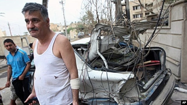 A Christian Iraqi man stands close to his destroyed vehicles parked close to the Sayidat al-Nejat Catholic cathedral, in central Baghdad, 1 Nov 2010