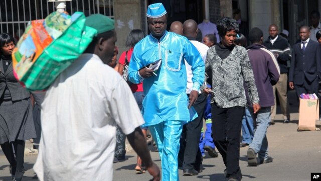 People walk down a street in the capital city of Zimbabwe, Harare, July, 12, 2012.