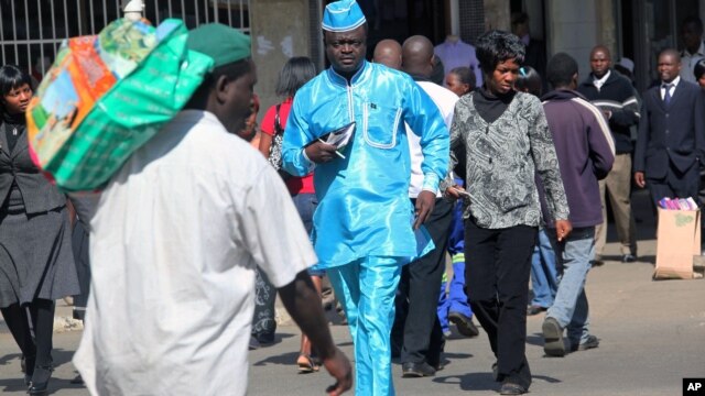 People walk down a street in the capital city of Zimbabwe, Harare, July, 12, 2012.