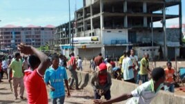 Peul youths throw stones toward members of the Malinke ethnic group, during clashes between Malinke and Peul shopkeepers in Conakry, Guinea, Sept. 21, 2012. 