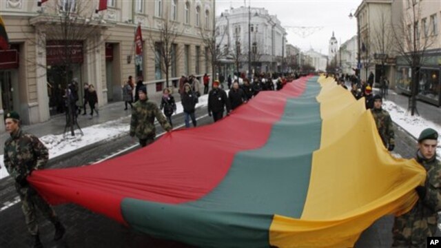 Lithuanians march during a celebration of the 20th anniversary of the  "Battle for the Freedom of Nations" carrying  a 200m long  sash  in the Lithuanian flag colors from the Cathedral Square to the Independence Square in Vilnius, Lithuania, 13 Jan 2011