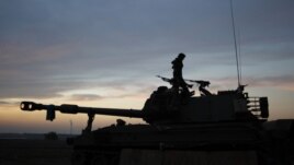 An Israeli soldier stands atop a mobile artillery unit positioned outside the northern Gaza Strip, November 21, 2012.