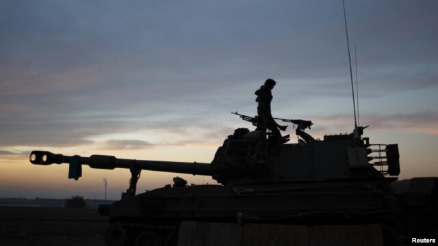 An Israeli soldier stands atop a mobile artillery unit positioned outside the northern Gaza Strip, November 21, 2012.