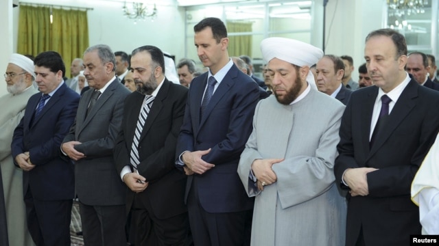 Syria's President Bashar al-Assad (3nd R ) attends Eid Al Fitr prayers at al-Hamad mosque in Damascus, August 19, 2012.