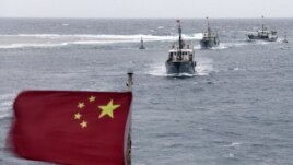 In this photo taken on Friday, July 20, 2012, Chinese fishing boats sail in the lagoon of Meiji reef off the island province of Hainan in the South China Sea.