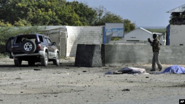 A Somali government soldier looks at a car laden with explosives which targeted the Mogadishu airport, 09 Sep 2010